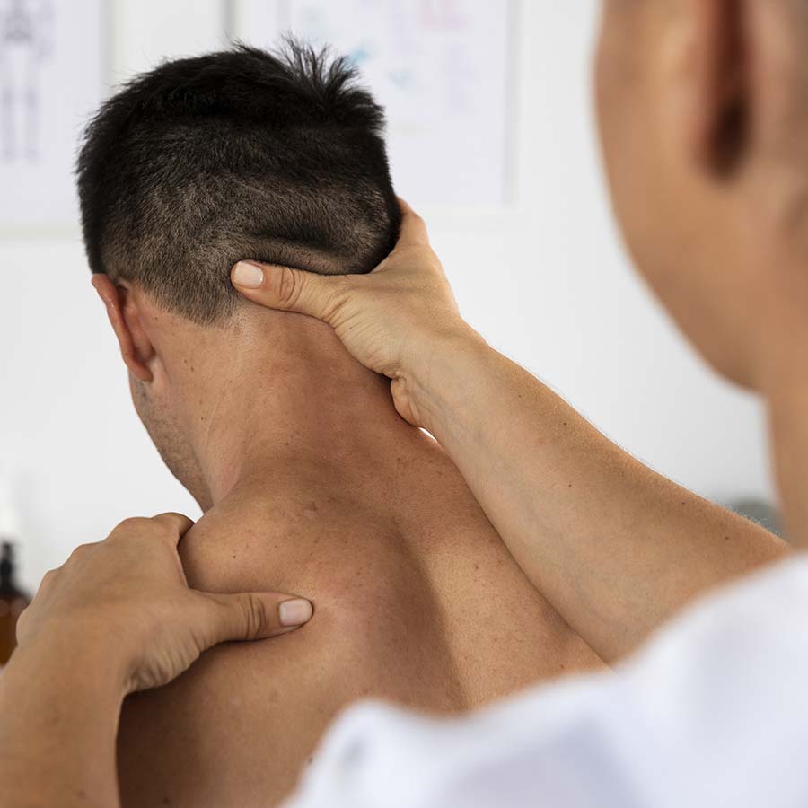 Hombre recibiendo un masaje terapéutico de una profesional de la osteopatía.